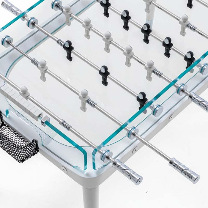 An overhead shot of the foosball table displaying its transparent glass surface, neatly arranged players, and sleek white frame.