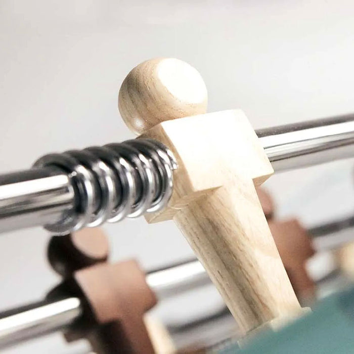 Close-up of a light wood player figure in action on the Teckell 90 Minuto foosball table.