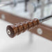 Close-up of the handle on the Teckell 90 Minuto walnut wood foosball table, displaying its intricate design and quality craftsmanship.