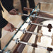 Hands gripping the wooden handles of the Teckell 90 Minuto foosball table, demonstrating its gameplay experience.