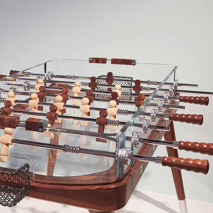 Close-up of the Teckell 90 Minuto walnut wood foosball table, featuring glass sides and finely crafted wooden handles.