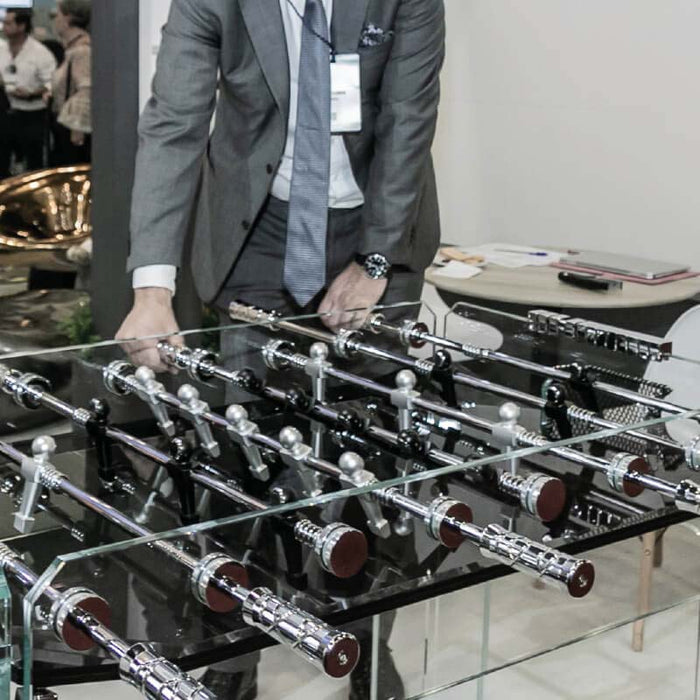 Man playing on the Teckell Cristallino Black Foosball Table at an event.