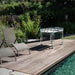 Teckell Fuoriclasse Foosball Table next to lounge chairs by the poolside, highlighting its outdoor suitability.