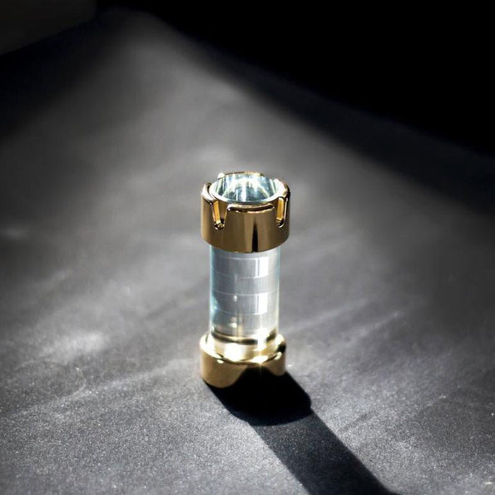 A detailed image of a single chess piece, featuring exquisite craftsmanship with a 24K gold-plated finish and clear borosilicate glass.