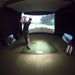 800 × 800px  Golfer in motion on True Strike Academy golf mat facing a curved simulator screen.