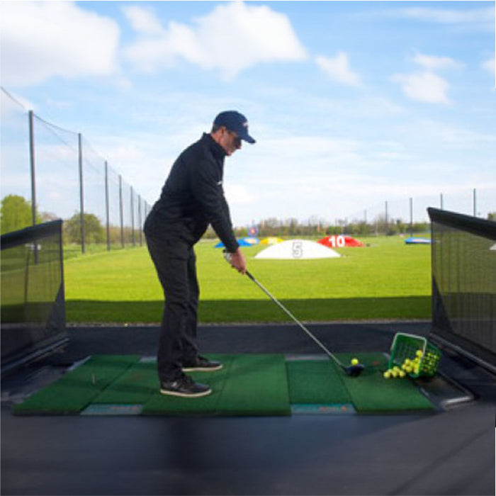 Man practicing on True Strike Double mat at outdoor driving range.