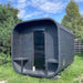 Ula Classic 6-person outdoor sauna in sleek charcoal black finish with integrated front benches, set up in a garden for a contemporary spa experience.