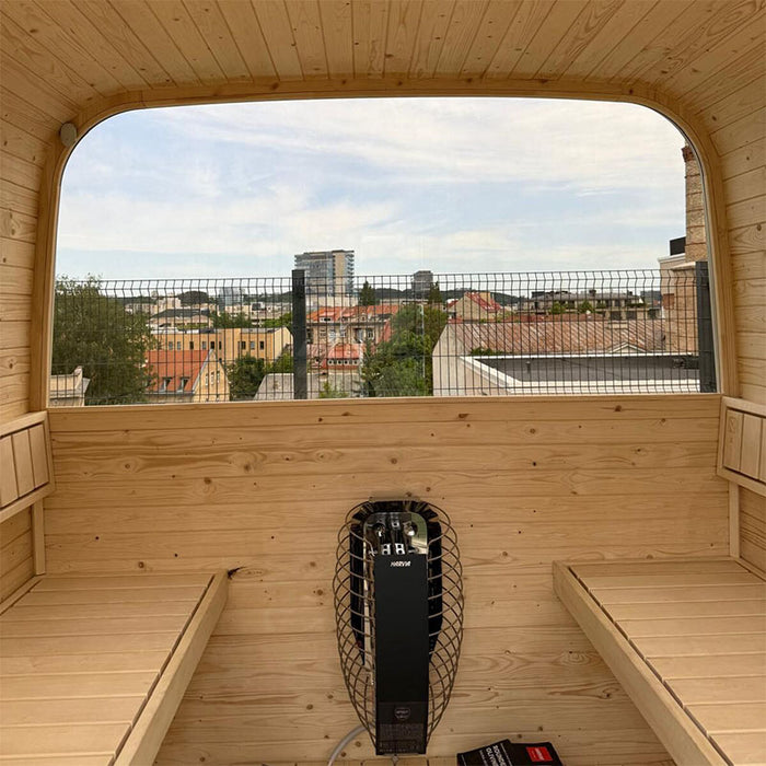 Interior of the Ula Classic 6-person sauna with natural light wood benches, curved ceiling, and Harvia heater, offering a spacious and calming spa environment.