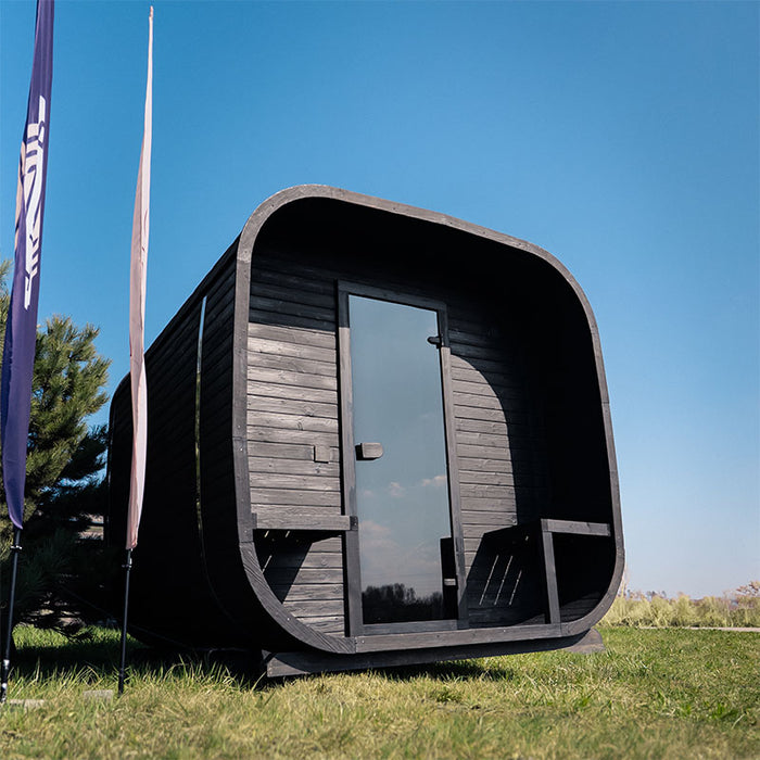 Front view of the Ula Grand 6-Person Outdoor Sauna in Ebony finish with covered porch and glass door.