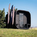 Ula Grand 6-Person Outdoor Sauna in Ebony finish shown outdoors on grass with trees and clear sky