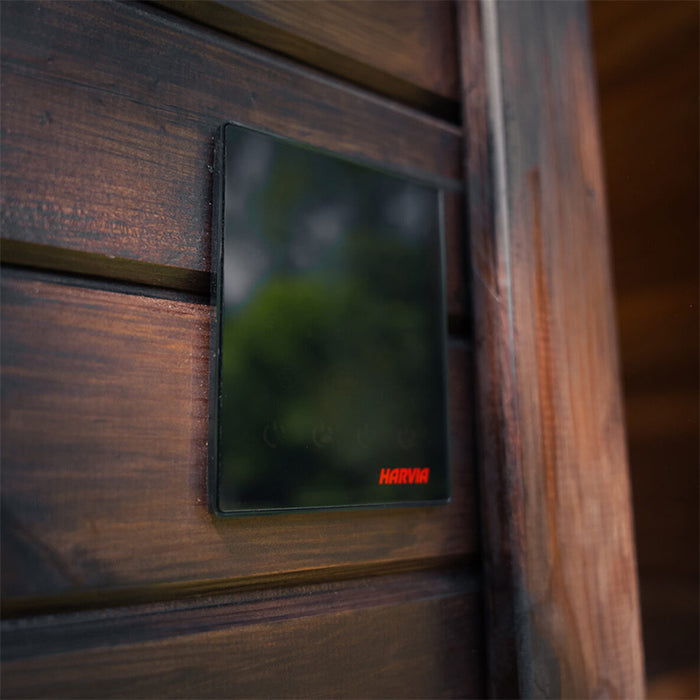 Harvia digital control panel mounted on the exterior wall of the Ula Mini 2-person sauna for precise temperature regulation.
