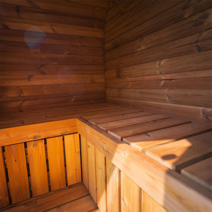 Interior wooden benching of the Ula Mini 2-person outdoor sauna, showcasing natural timber finish and L-shaped seating.