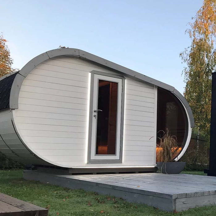 Side view of Delight Outdoor Sauna with illuminated door.