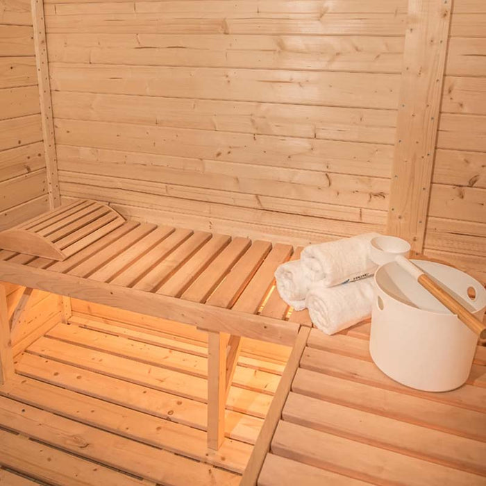 Wooden interior with bucket, ladle and towels on benches of Delight Outdoor Sauna 2.4 x 4.3m.