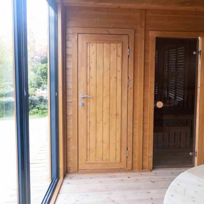 Close-up of the wooden door inside the Garden Cube 3 x 8m, showcasing its high-quality finish, natural wood grain, and sleek handle. The adjoining glass door reveals the cosy sauna space, adding warmth and a modern touch to the overall design.