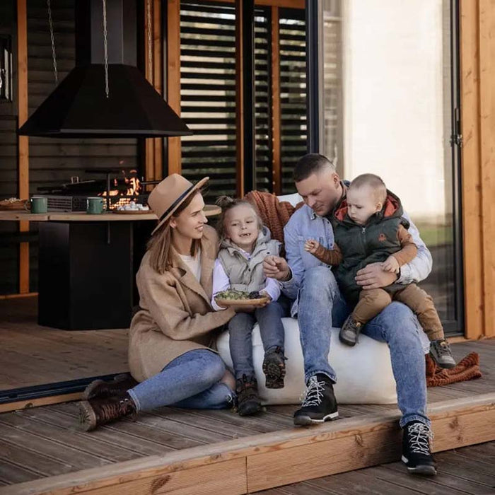 A relaxed family gathering near the integrated barbecue area, illustrating the Garden Cube's versatility for hosting loved ones.