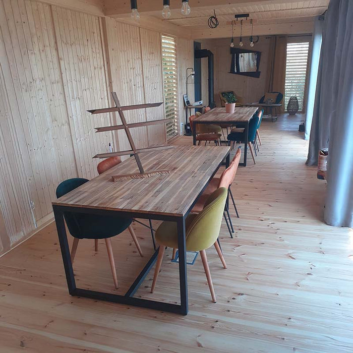 Spacious dining area interior of the Glamping Cube 51m² U-Shape, featuring wooden furniture and vibrant decor.