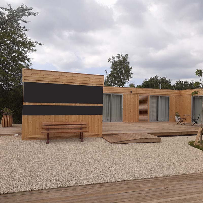 Front daytime view of the Glamping Cube 51m² U-Shape featuring modern glass windows and wooden cladding.