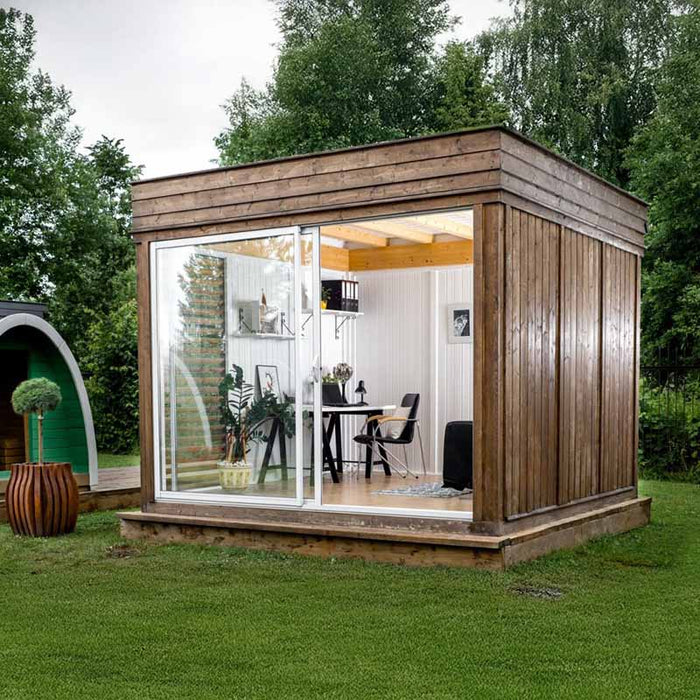 Wood-clad Insulated Garden Office Cube 3 x 4m with glass doors, offering a cosy workspace set in lush garden surroundings.