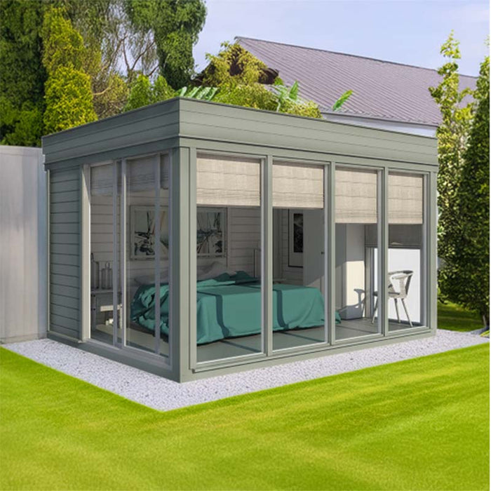 Insulated Garden Room 3 x 4m with wide glass panels, set in a lush green garden, creating a private, light-filled retreat. Ideal as a year-round outdoor living space.