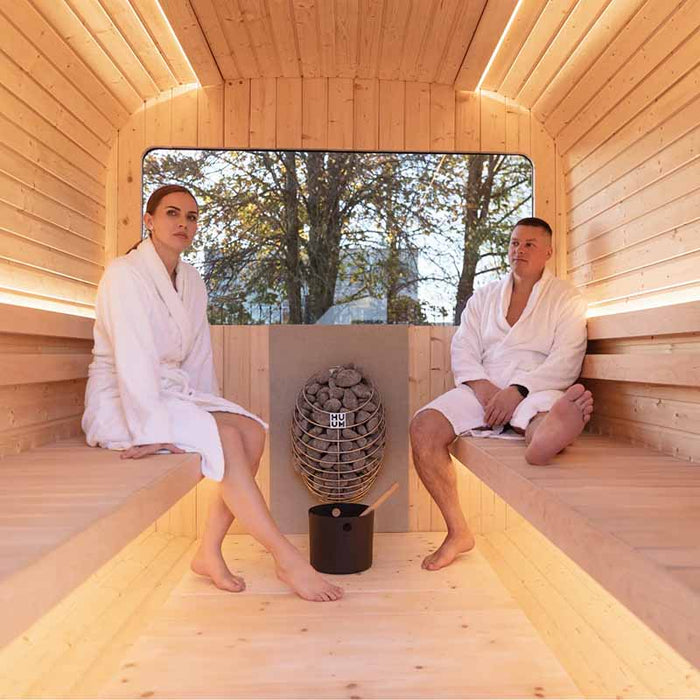 Couple sitting in Luna Sauna 2.3 x 2.4m with heater, bucket and ladle. 