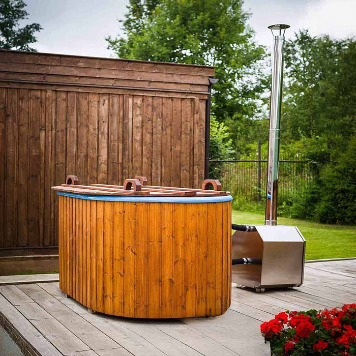 Fiberglass Ofuro Hot Tub with a metal stove, placed on a wooden deck with a garden backdrop.