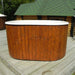 Oval-shaped Fiberglass Ofuro Hot Tub with a white interior, on a wooden deck.