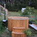 Fiberglass Ofuro Hot Tub with a wooden cover and steps, placed near a metal stove in a garden.