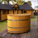 Oval cold tub placed outside a log cabin.