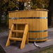 Oval cold tub with wooden steps for easy access.