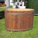 Oval cold tub with a wooden lid, placed on the grass.