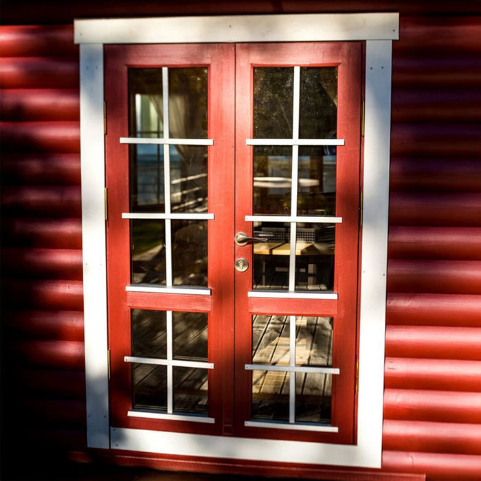 Exterior view of the Pavilion 14.9m² with vibrant red walls, white accents, and a durable black roof.