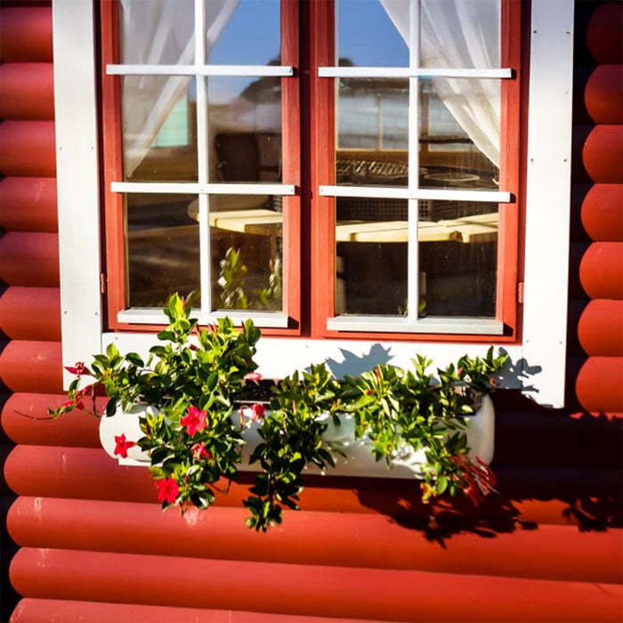 Close-up of Pavilion 14.9m²'s double-glazed windows adorned with charming white curtains, ensuring natural light and insulation.