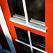 Close-up of the Pavilion 14.9m²'s red and white window frame, showcasing its elegant and weatherproof design.