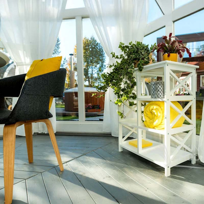 Close-up of the Pavilion with Large Windows 10m² interior, showcasing a stylish shelving unit with decorative plants and bright yellow accents, framed by large glass windows and elegant white curtains that invite natural light.