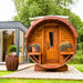 The Traditional Sauna Barrel situated on a wooden deck in a garden area.