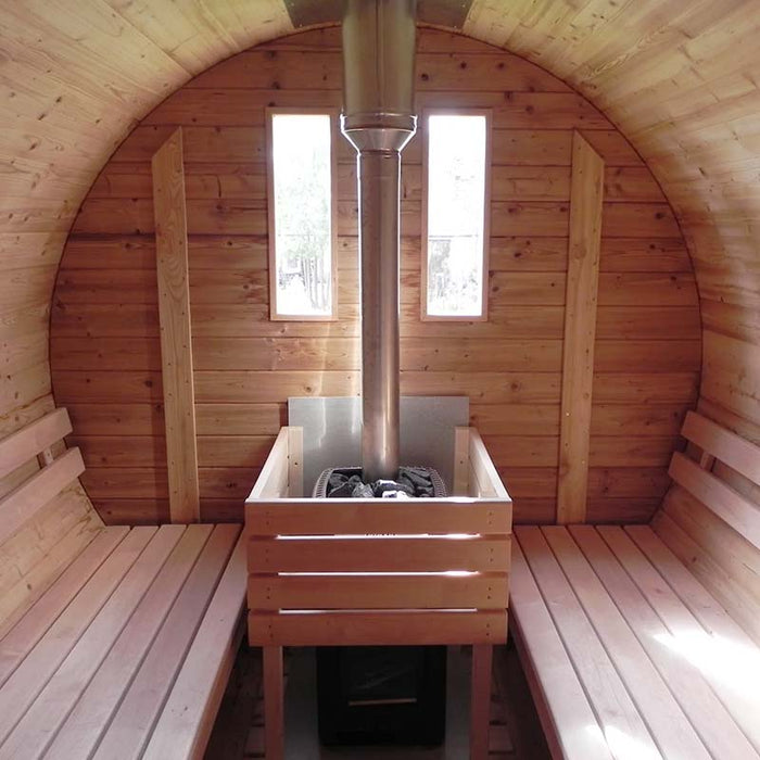 Traditional barrel sauna interior with a central wood-burning stove and benches on both sides.