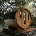  The Traditional Sauna Barrel 1.9 x 3m positioned on a wooden deck with a stone foundation visible underneath.