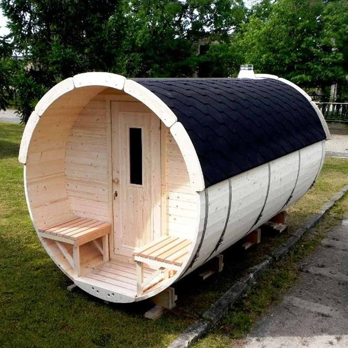 The Traditional Sauna Barrel 2.2 x 4m positioned in paved surface with grass and trees in the background.