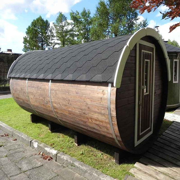 A Traditional Sauna Barrel 2.2 x 4m set outdoors on a grassy area.