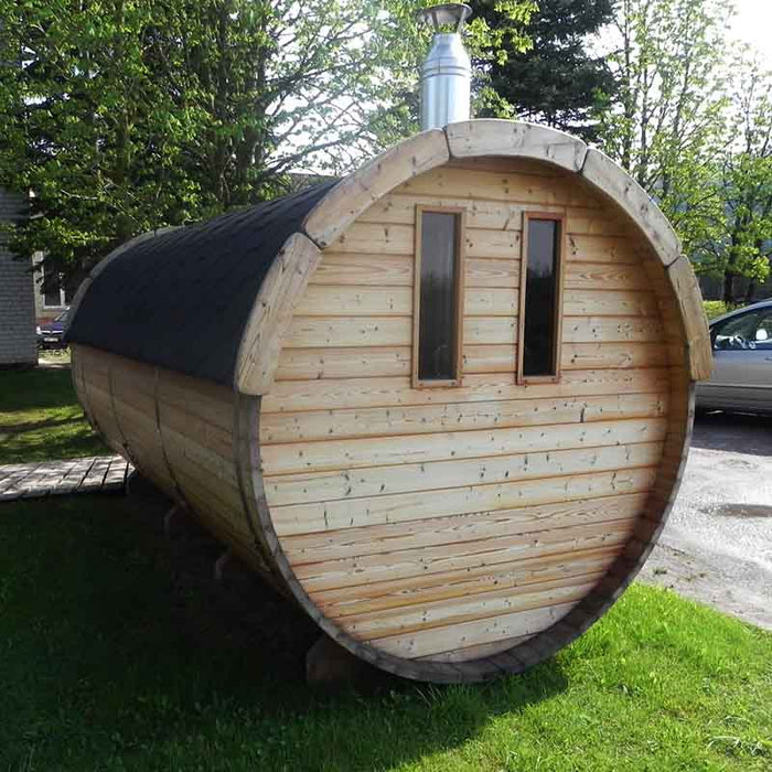 The Traditional Sauna Barrel 2.2 x 4m positioned on grass next to a paved area where a car is partially visible.