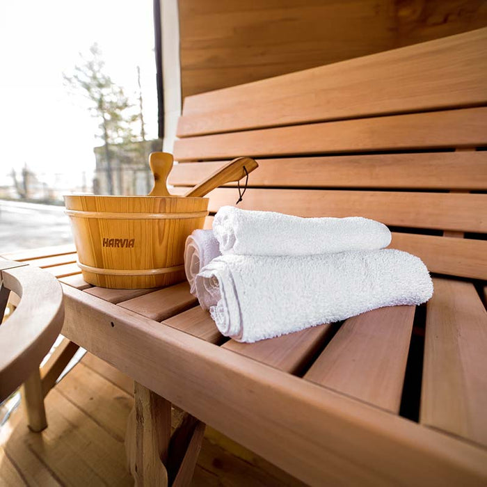 Close-up view of bucket and towel on wooden bench of Sauna Barrel from Thermowood.