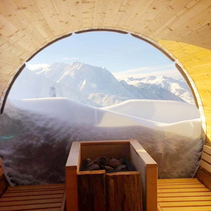 Sauna Barrel from Thermowood with heater, looking over snowy mountains.