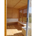 Main entrance of Sauna Cube 3 x 4m with with pillowed benches and windows in the background. 