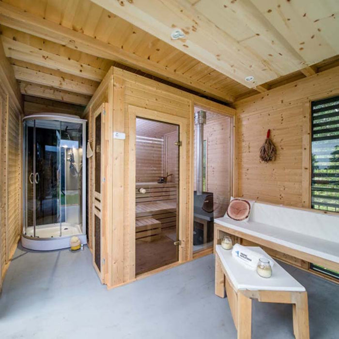 Interior view of Sauna Cube with integrated sauna, shower and wooden furniture.