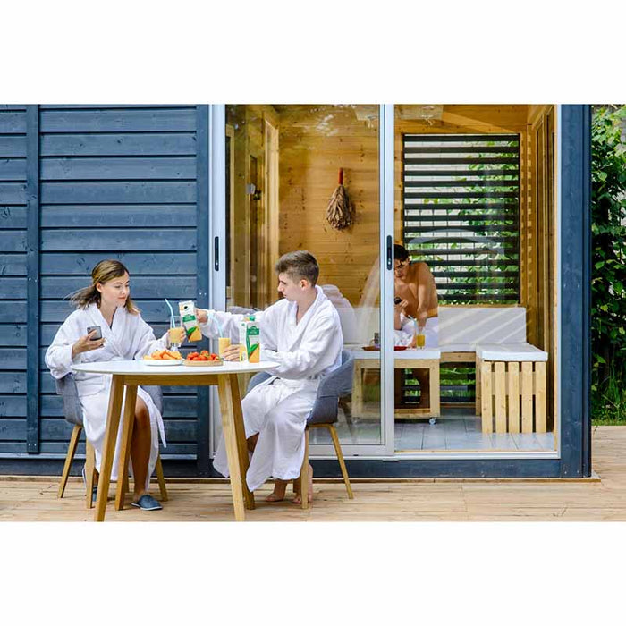 People having a meal in front of the Traditional Sauna Cube 3 x 4m with Lounge.