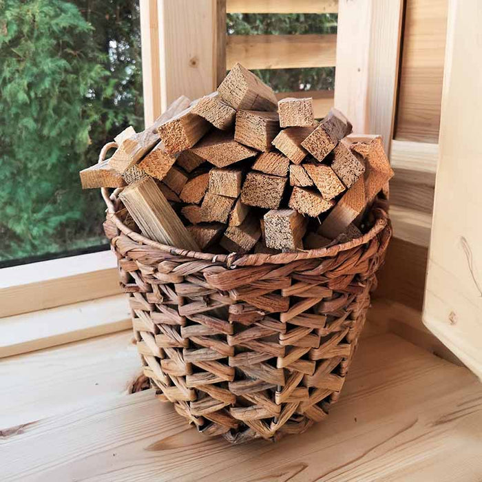 A basket of wood inside the Traditional Sauna Cube 3 x 4m with Lounge.