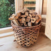 A basket of wood inside the Traditional Sauna Cube 3 x 4m with Lounge.