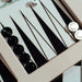 Close-up of the Vismara luxury backgammon set with premium black and silver counters and a sleek white frame, showcasing artisanal craftsmanship.