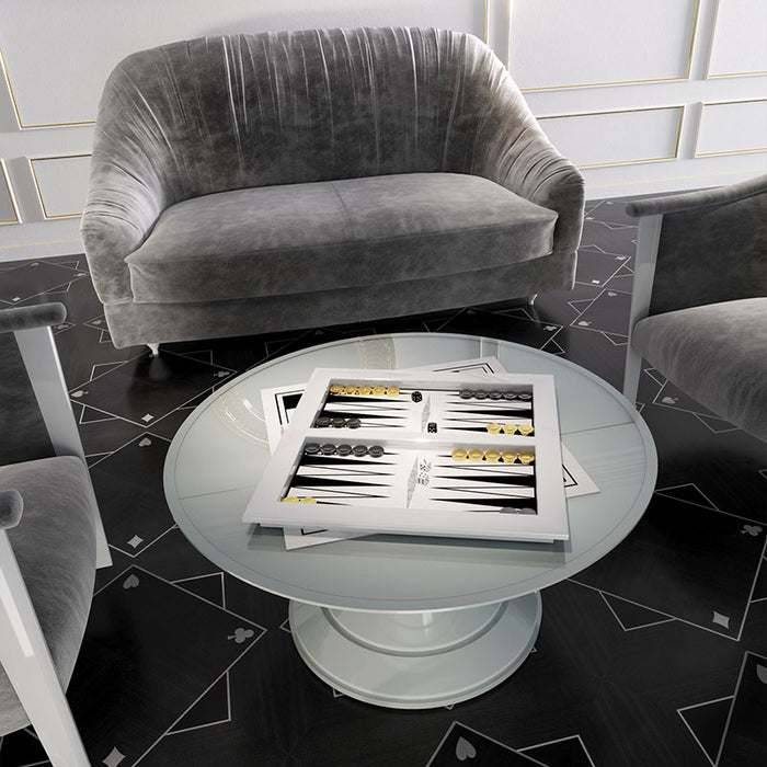 Vismara backgammon table in a chic monochrome interior with grey velvet seating and a modern round glass table, offering a sophisticated game room experience.